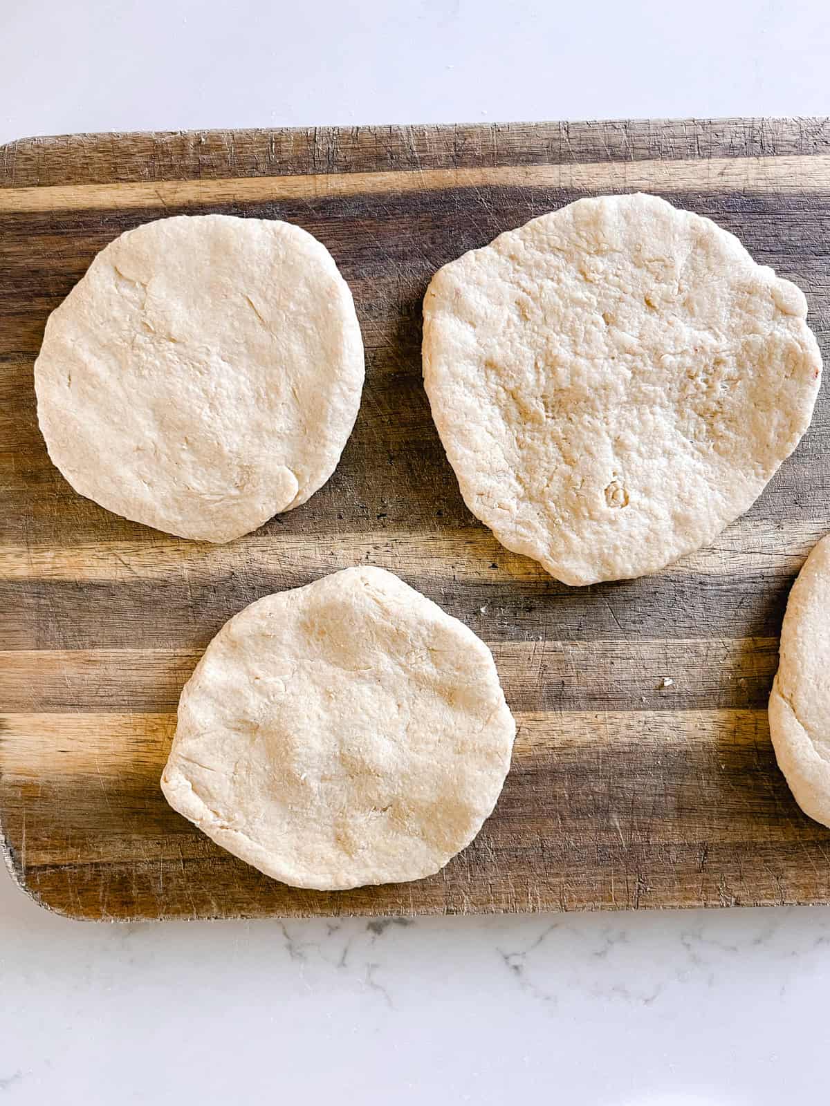 Freshly milled flatbread dough formed into flat circles.