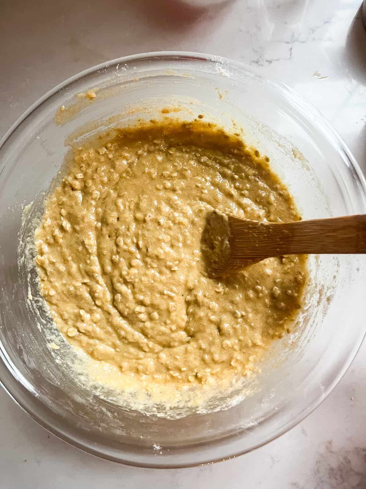 Mixing wet ingredients in a glass bowl.