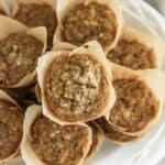 A white plate stacked high with banana oat muffins.