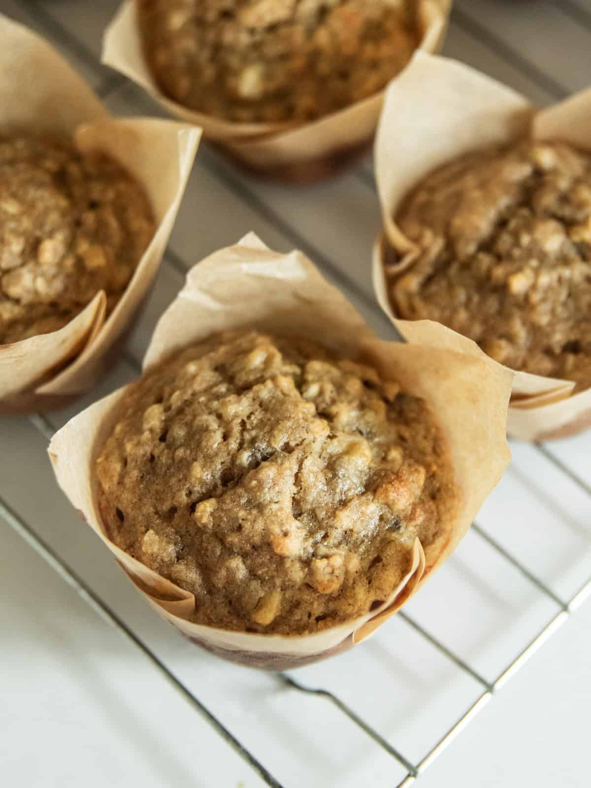 Close up on a banana oat muffin with more muffins in the background.
