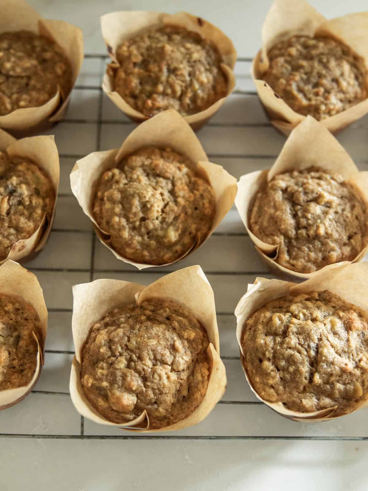 Banana oat muffins lined up on a cooling rack.