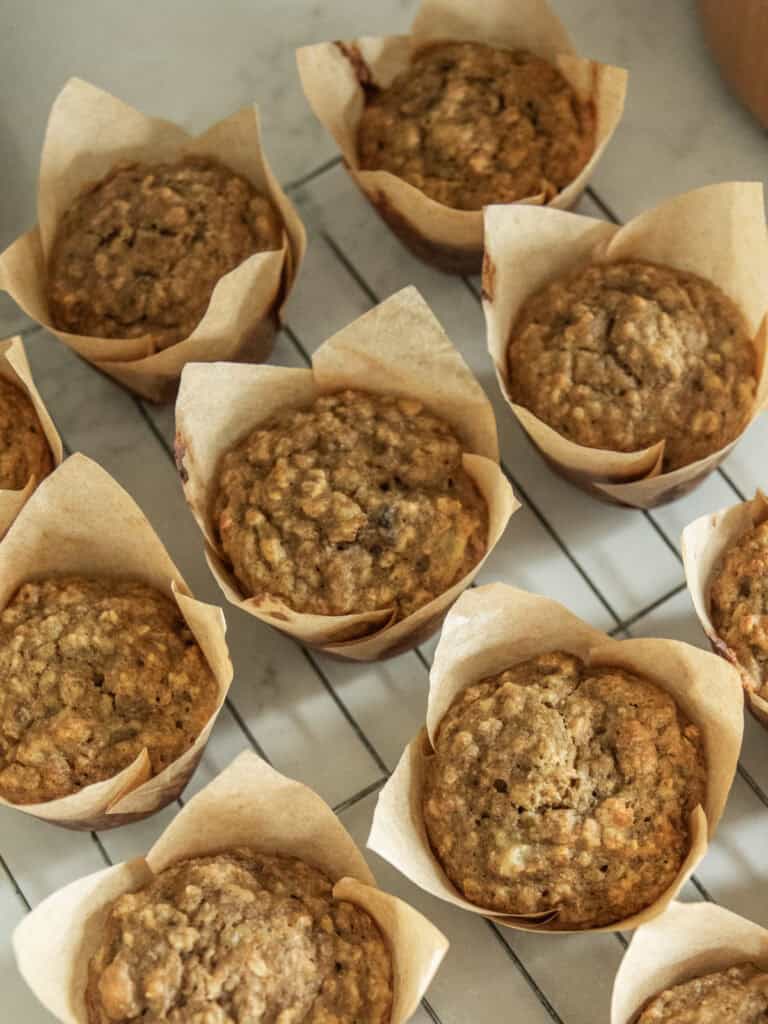 Several banana oat muffins on a cooling rack.