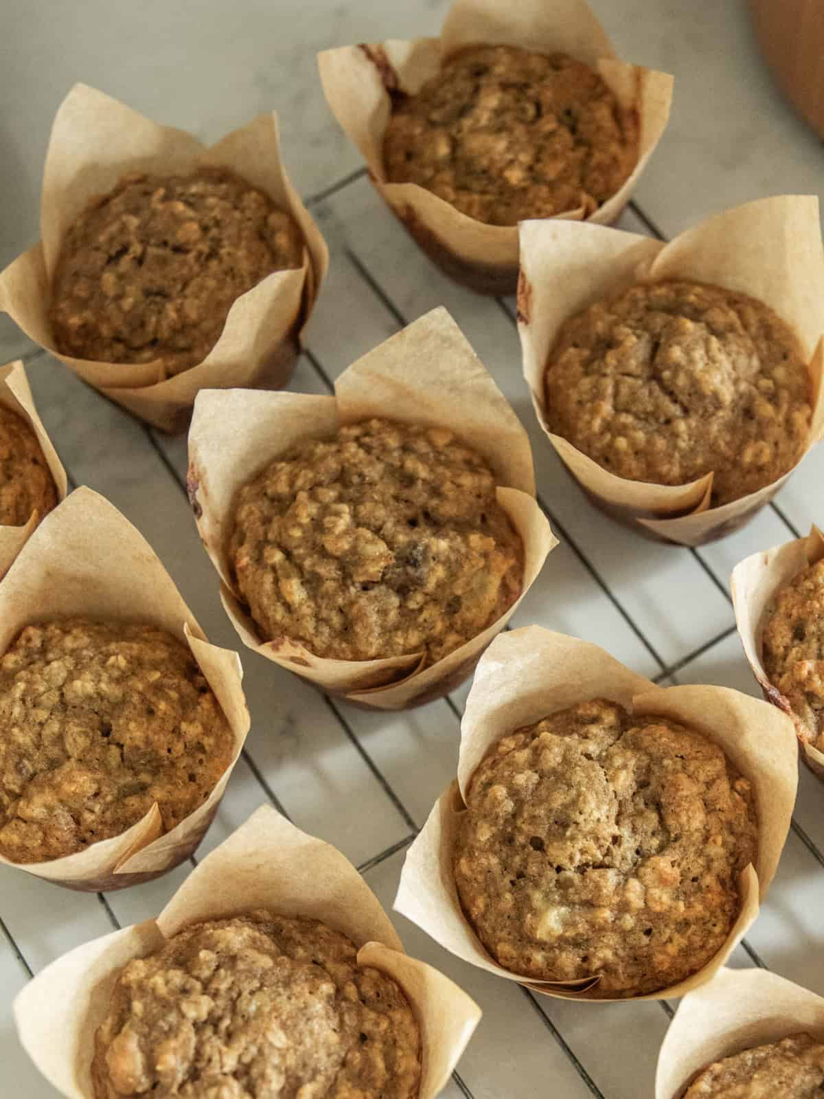 Several banana oat muffins on a cooling rack.