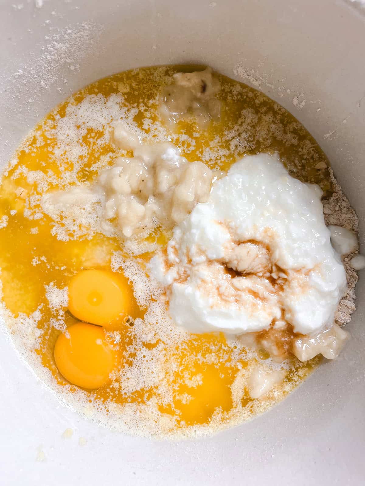 Wet ingredients added to a mixing bowl of dry ingredients.