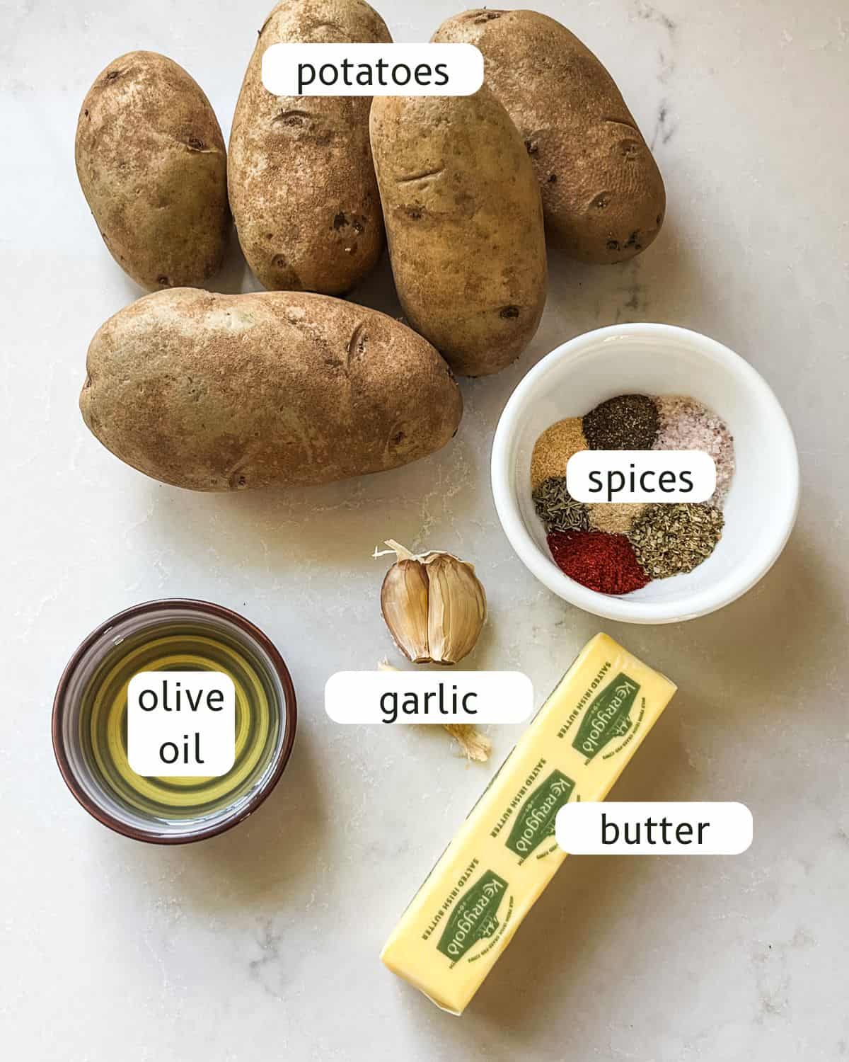 Cast iron skillet potatoes ingredients labeled on a kitchen counter.