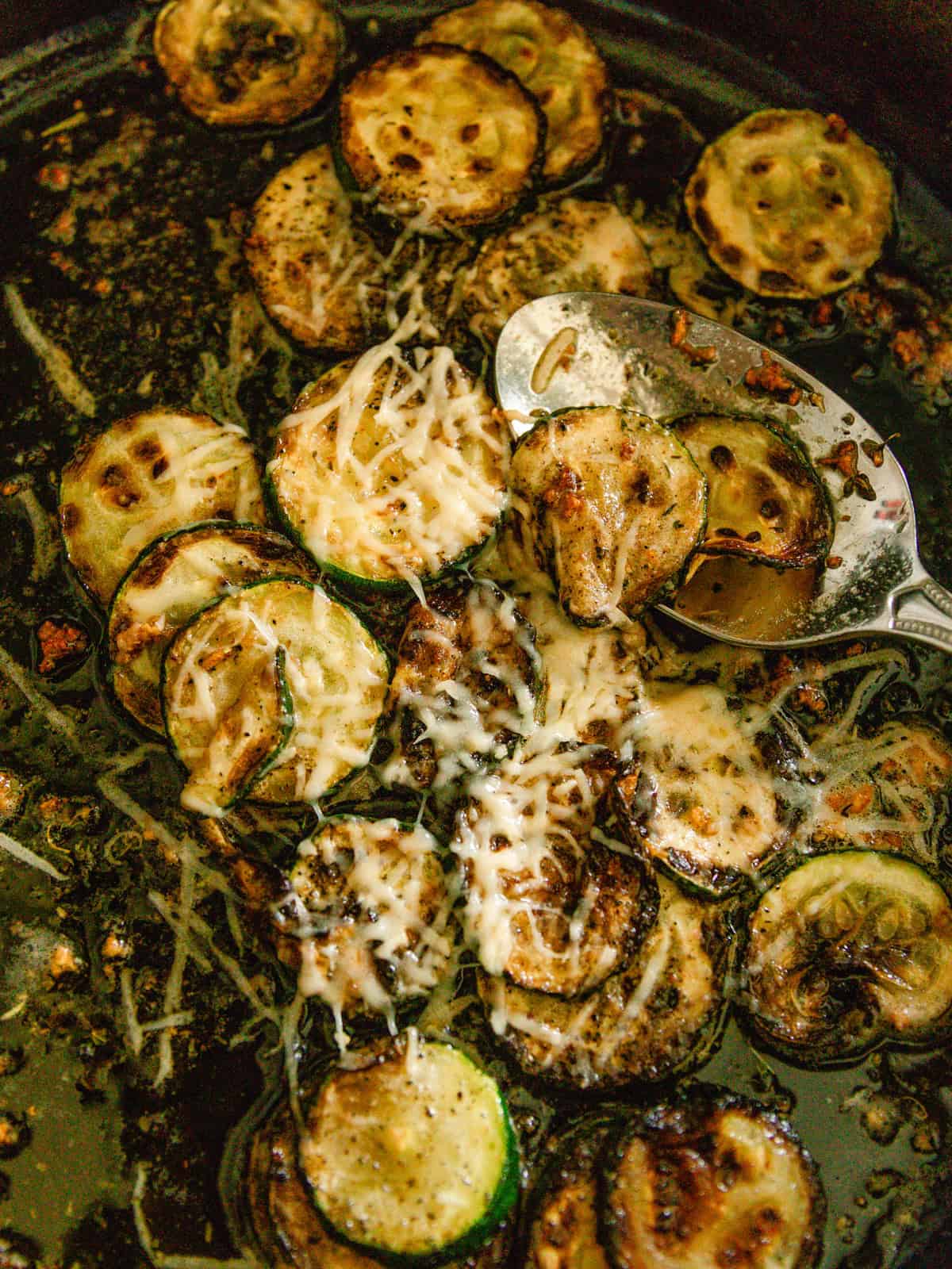 Golden browned zucchini n a cast iron skillet.