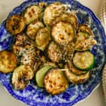 Cast iron skillet zucchini on a blue plate.