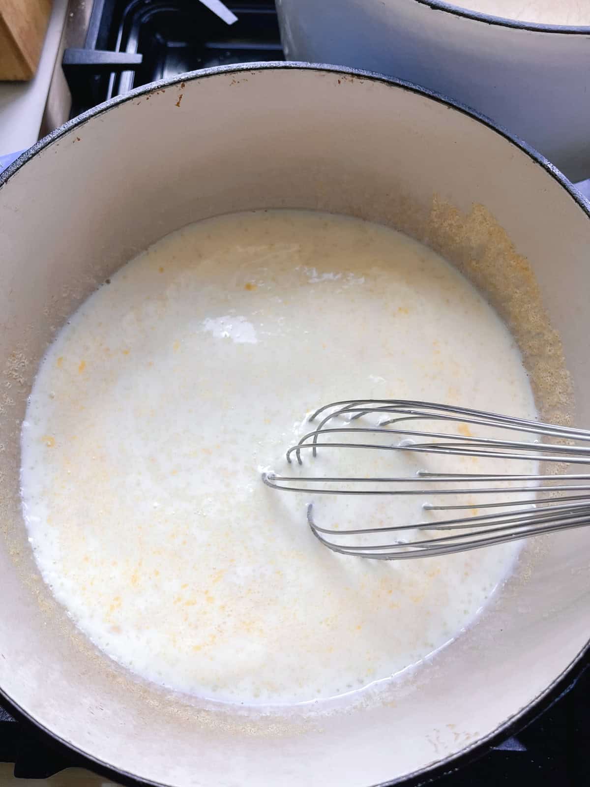 Stirring milk with a whisk.