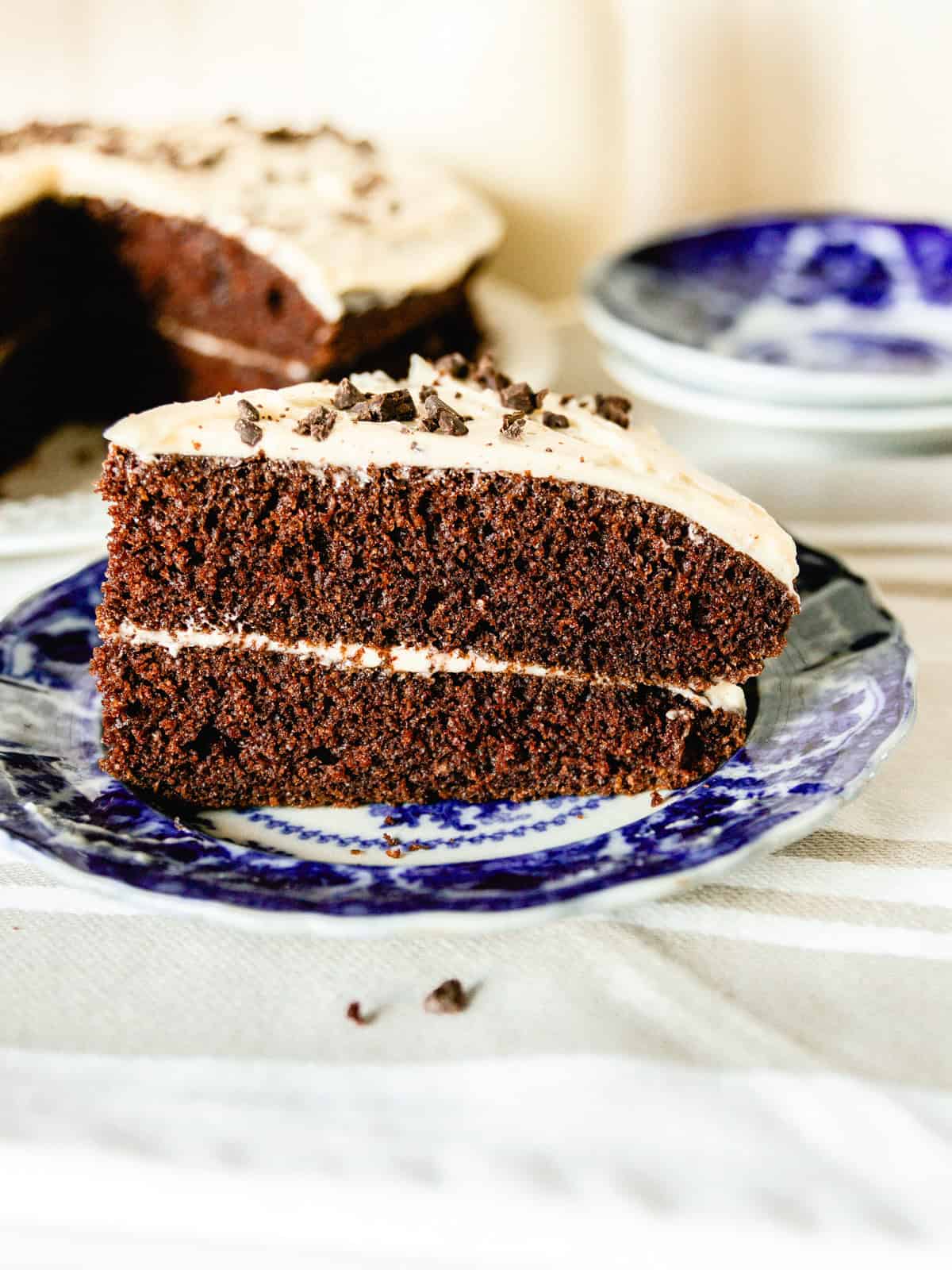 A slice of freshly milled whole wheat chocolate cake on a blue plate.