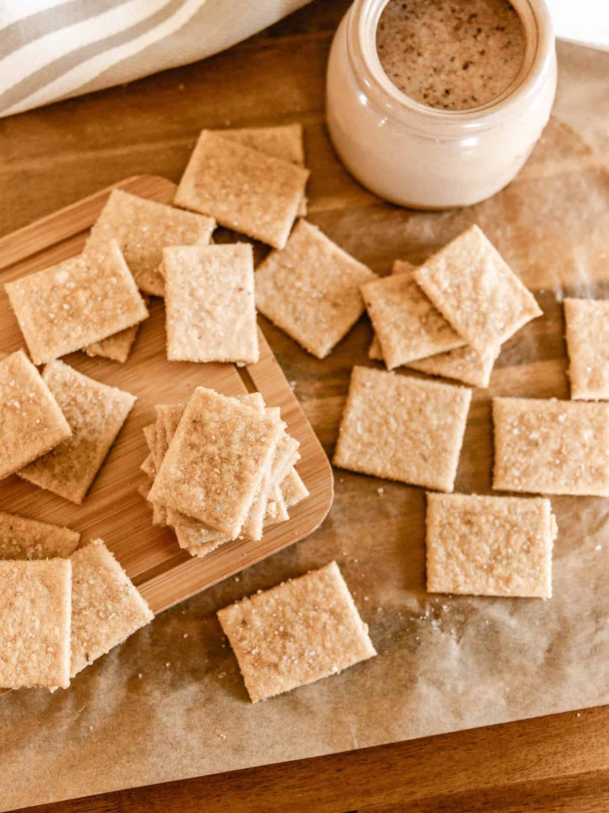Fresh milled flour crackers on a sheet of parchment paper with a salt well to the side.