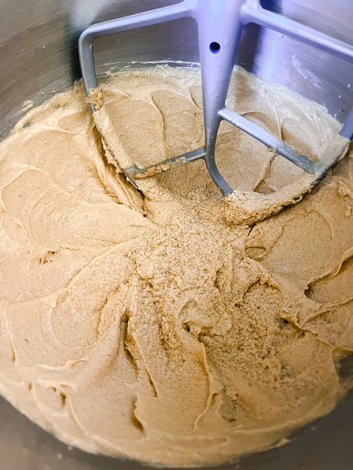 Whisking cake batter in a stand mixer with a paddle attachment.