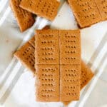 Whole wheat graham crackers spread out on a striped towel.