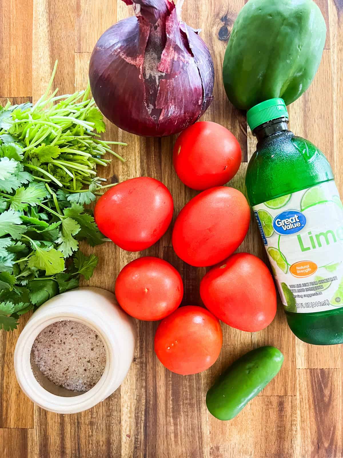 Pico de gallo ingredients assembled on a wooden cutting board.