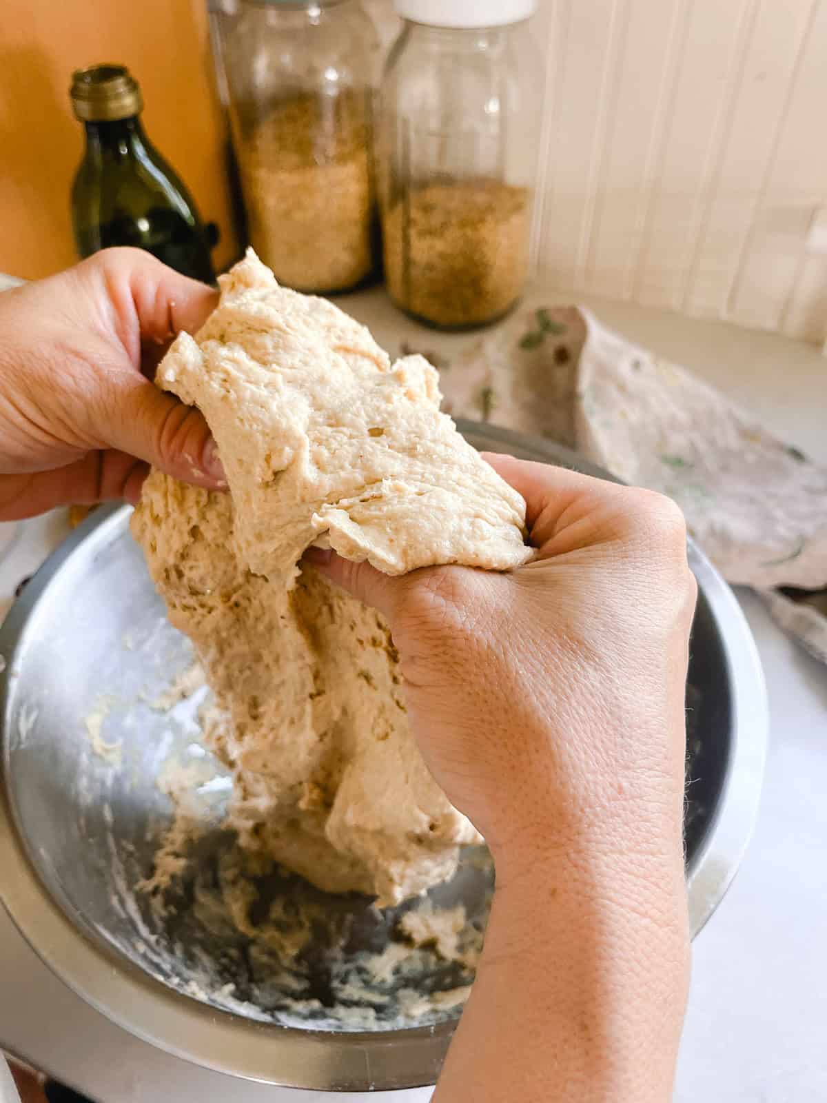 Performing stretch and pulls on the focaccia dough.
