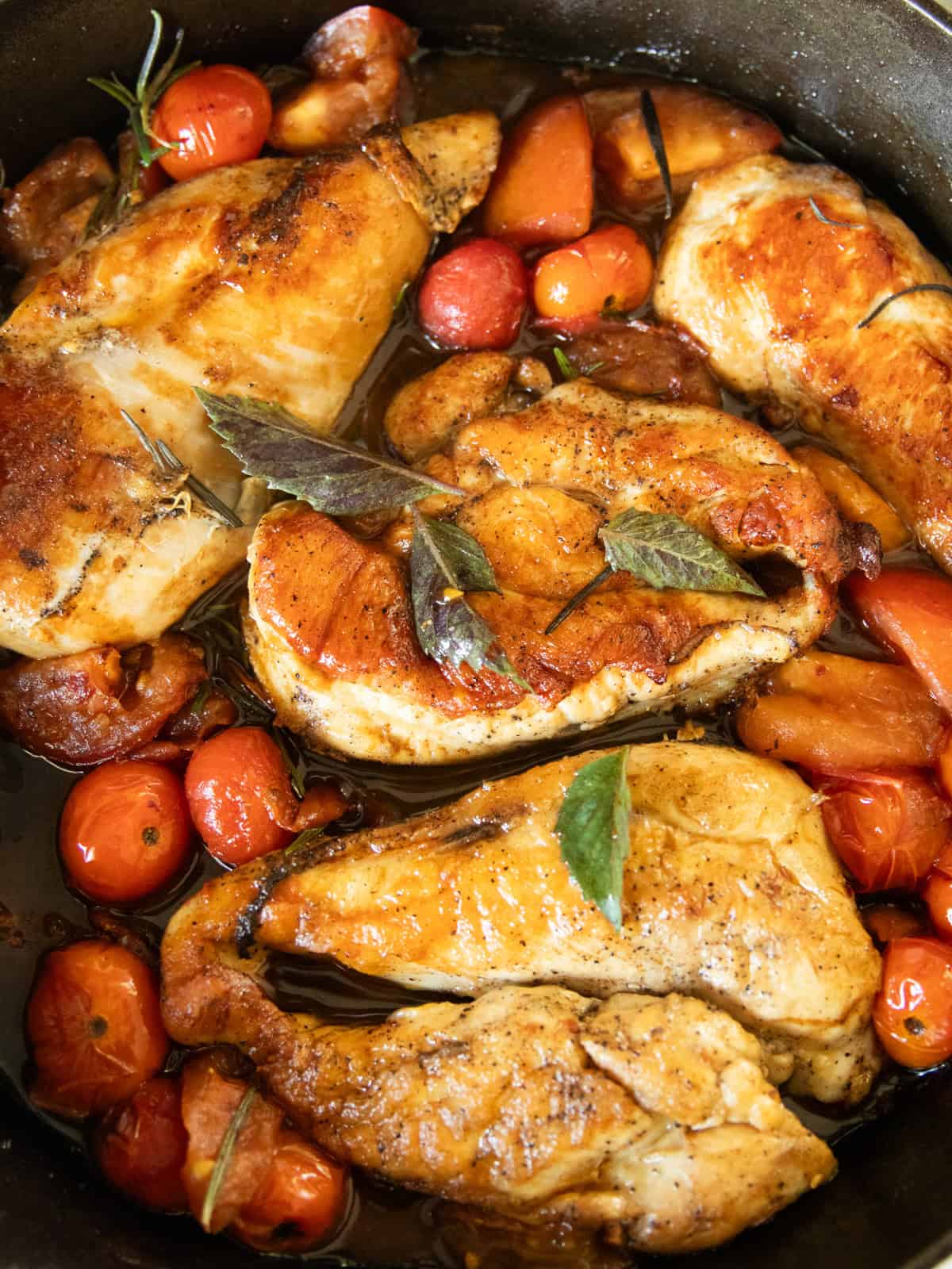 Cherry tomato herb chicken in a cast iron skillet.