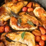 Cherry tomato and herb chicken in a cast iron skillet.