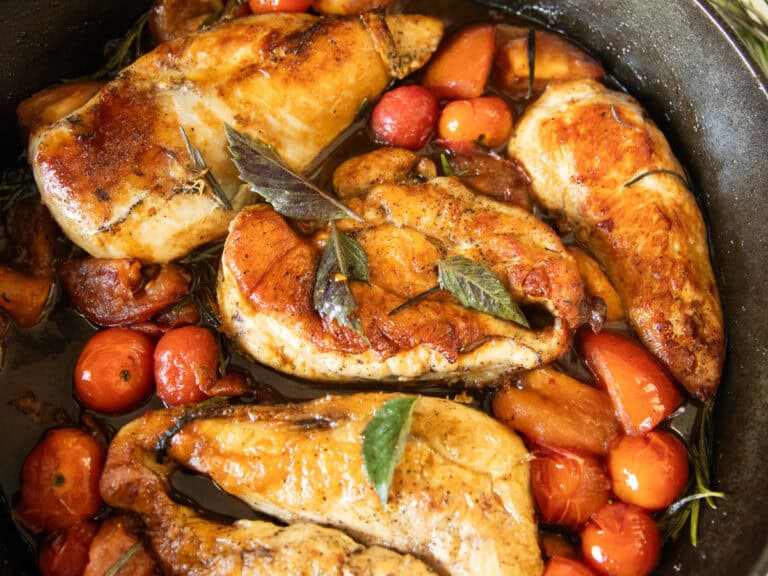 Cherry tomato and herb chicken in a cast iron skillet.