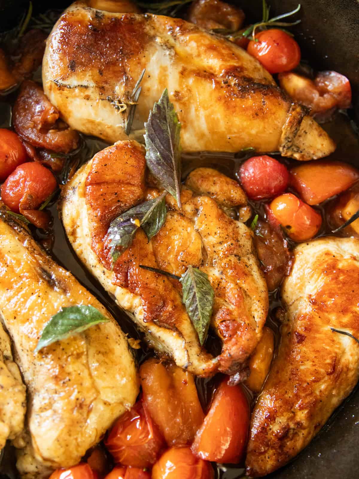 Cherry tomato and herb chicken in a cast iron skillet.
