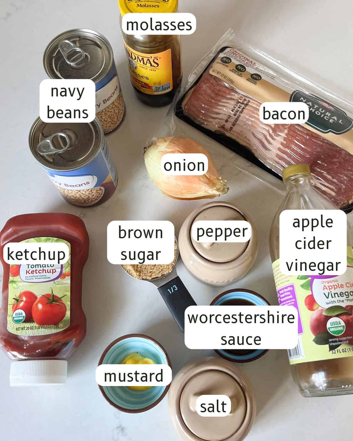 Skillet baked beans with bacon ingredients labeled on a kitchen counter.