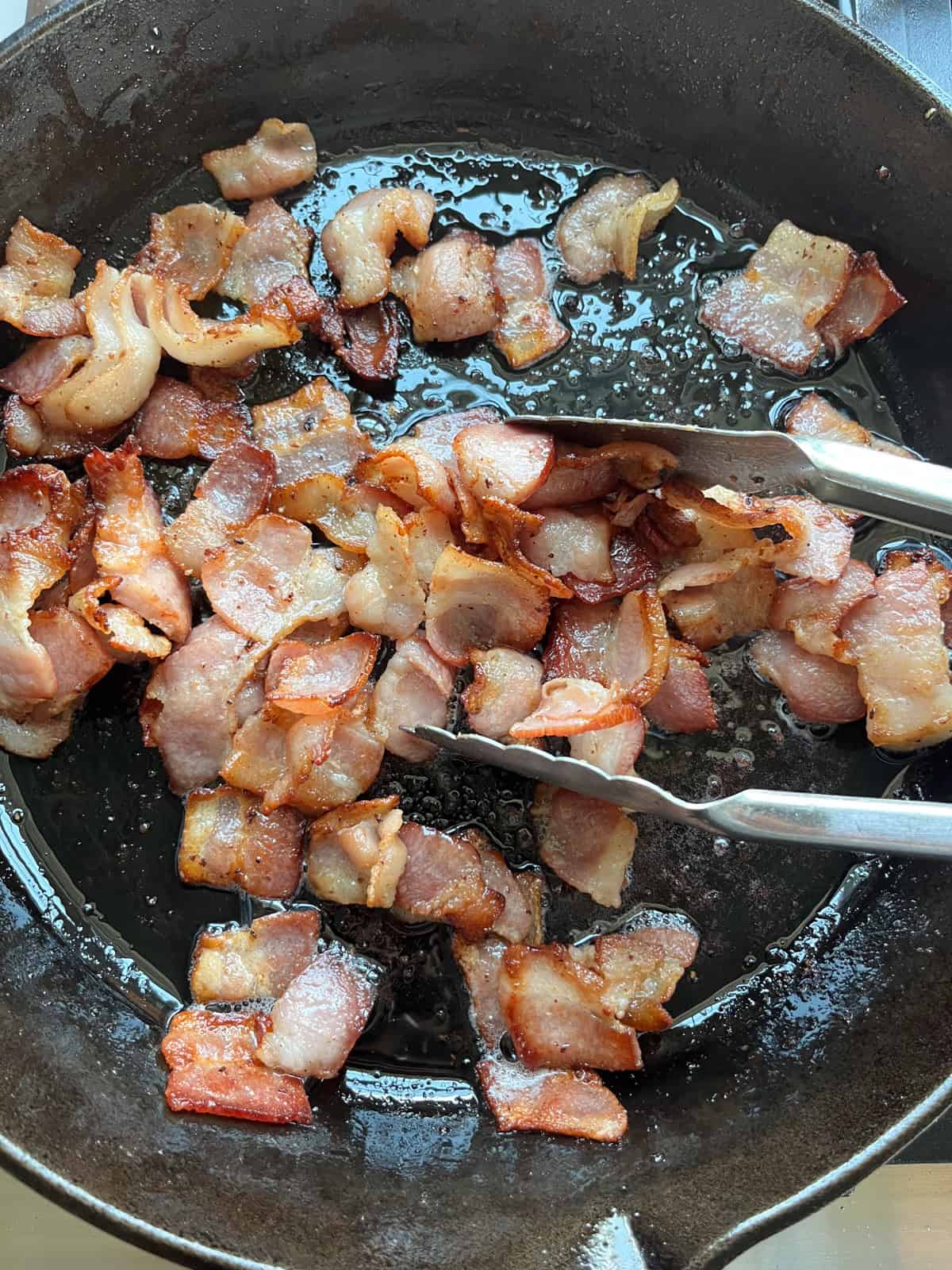 Cooking bacon in a cast iron skillet.