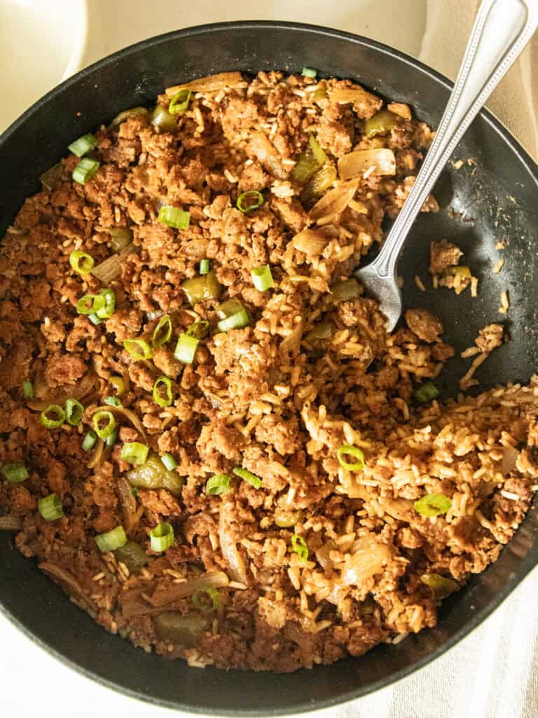 Cajun sausage and rice skillet with a serving spoon.