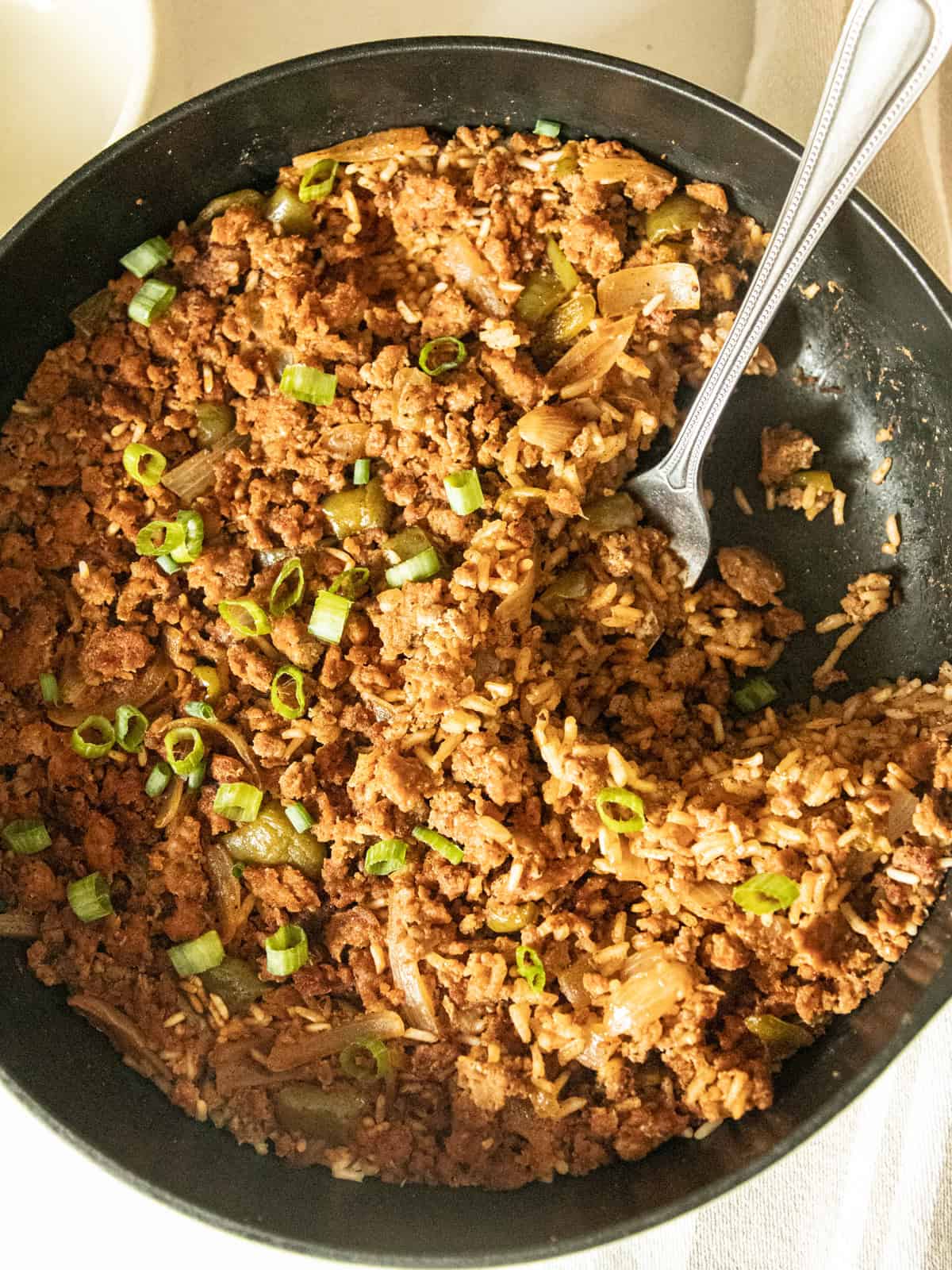 Cajun sausage and rice skillet with a serving spoon.
