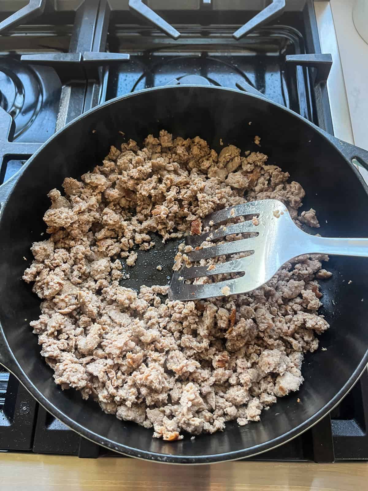 Browning pork sausage in a skillet.