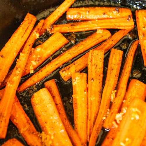 Cast iron glazed carrots in a skillet.