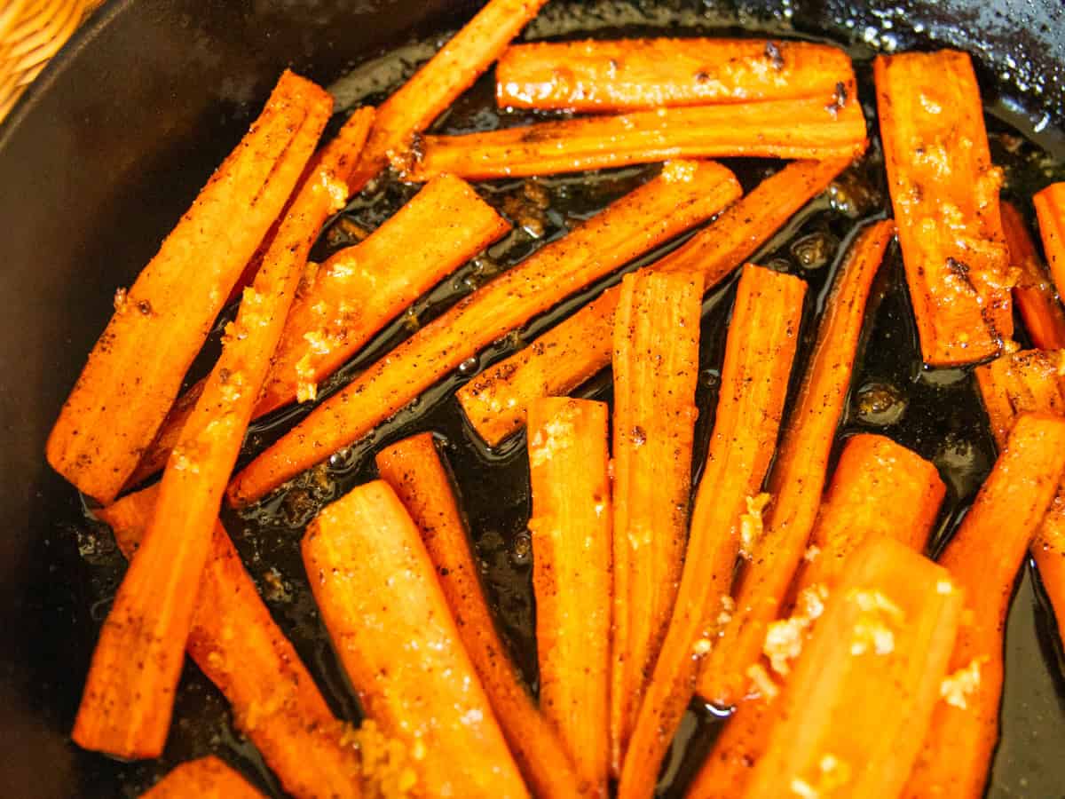 Cast iron glazed carrots in a skillet.