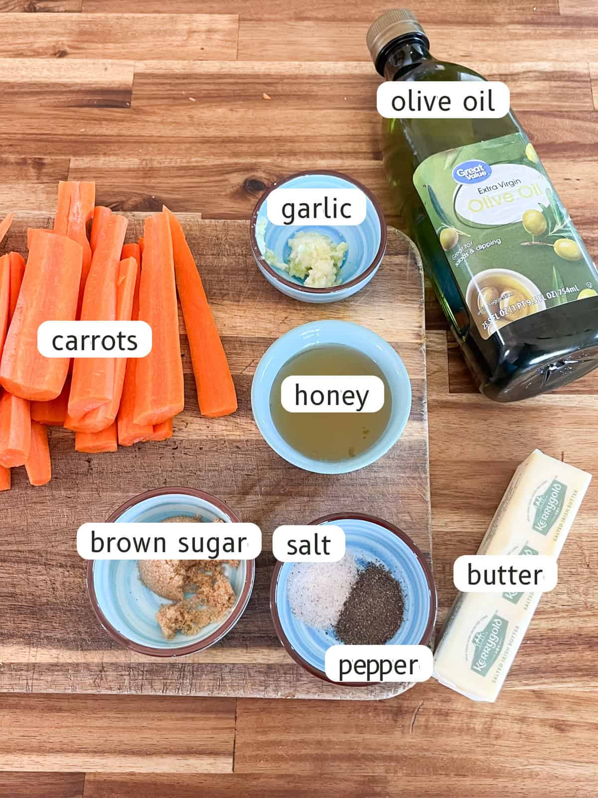 Cast iron glazed carrots ingredients labeled on a wooden butcher block.