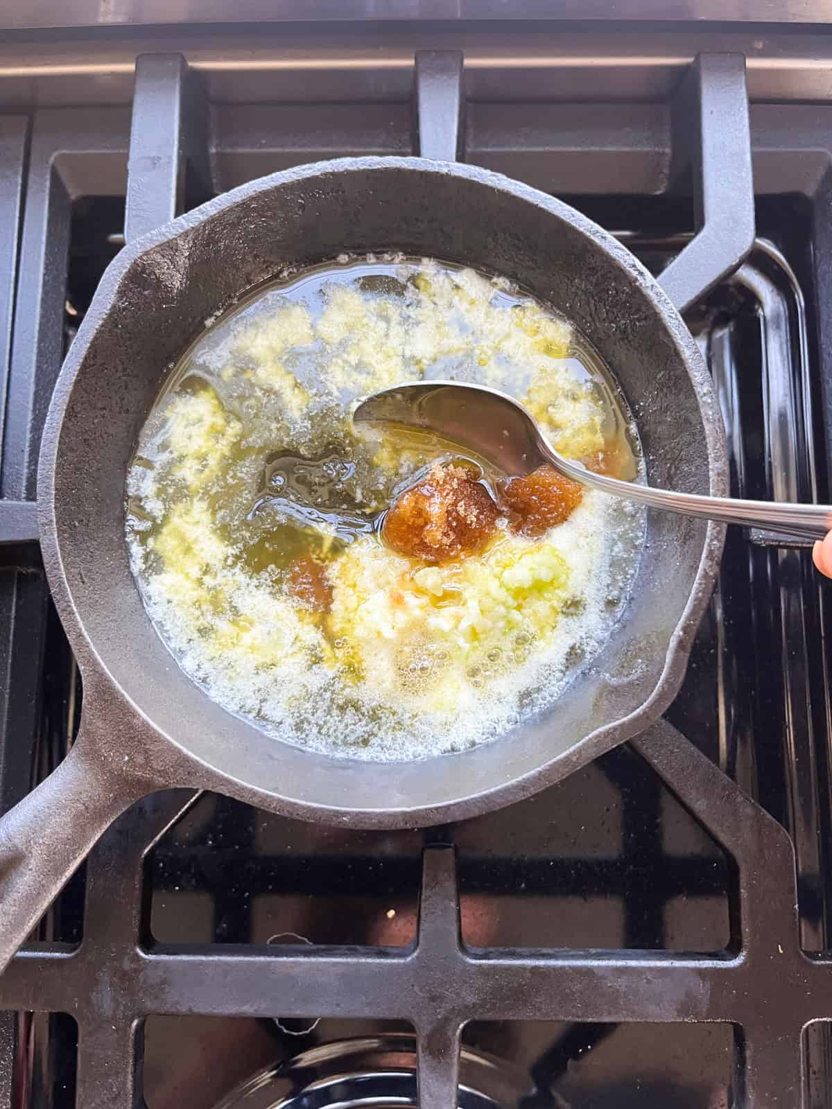 Melting a carrot glaze in a small saucepan.
