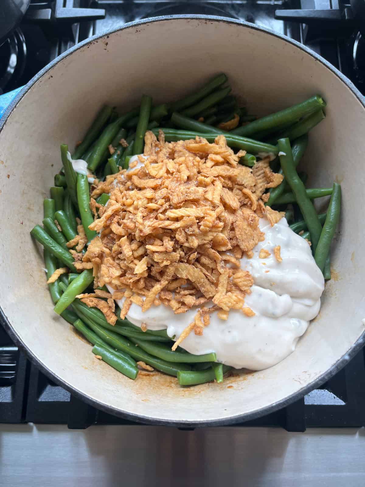 Other ingredients added to a dutch oven of steamed green beans.