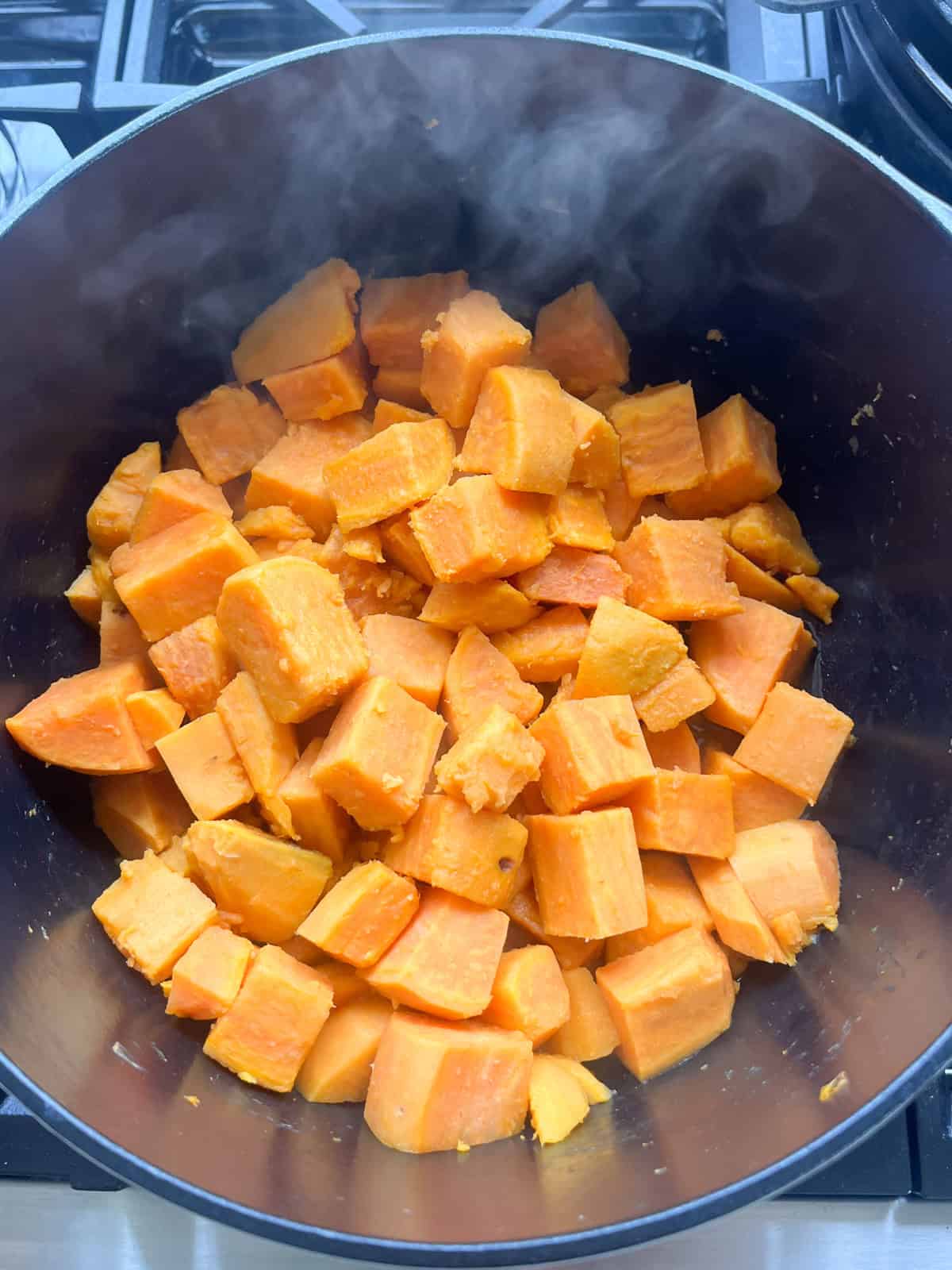 Cooked, cubed sweet potatoes in a Dutch oven.