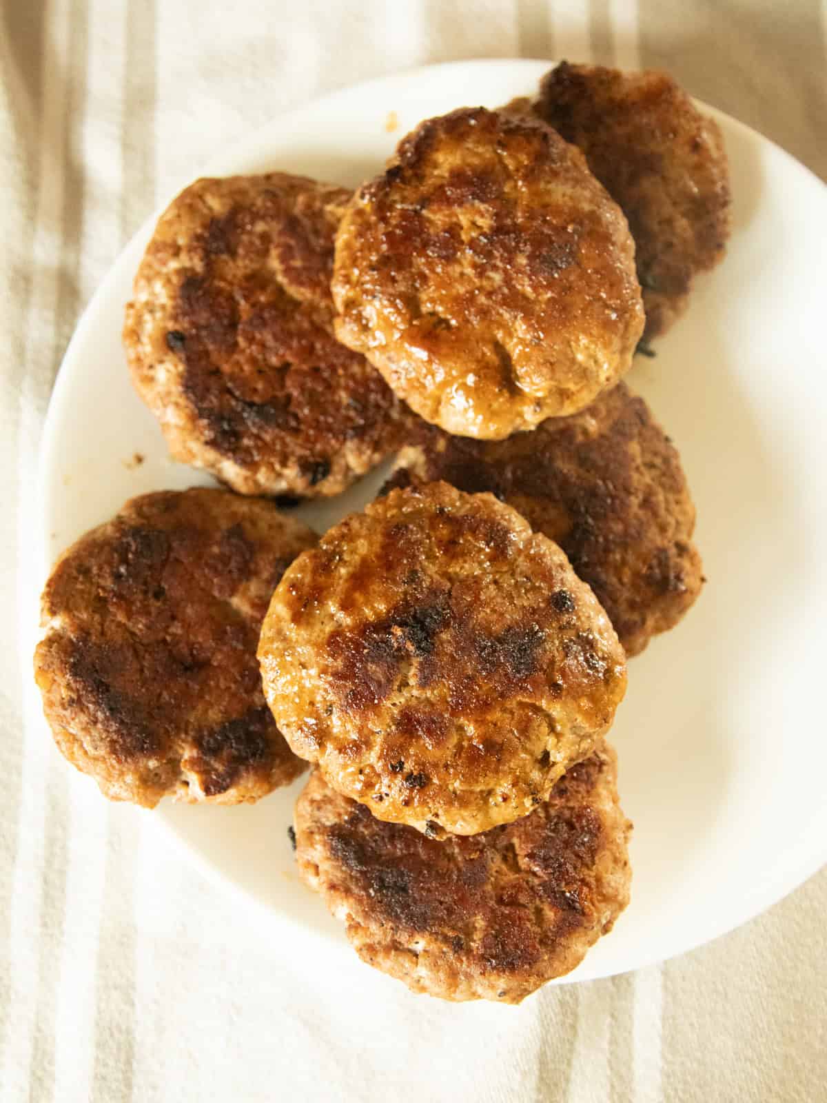 Homemade breakfast sausage patties on a white plate.