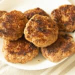 Homemade breakfast sausage patties on a white plate.