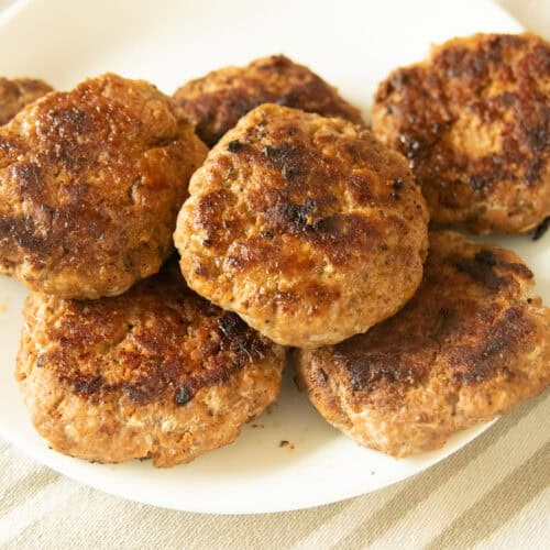 Homemade breakfast sausage patties on a white plate.