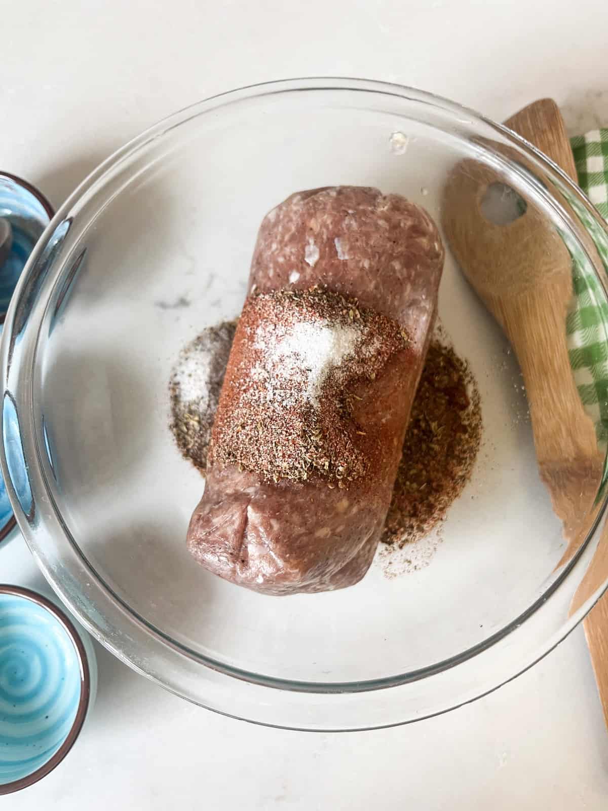 Sausage and other ingredients in a glass bowl.
