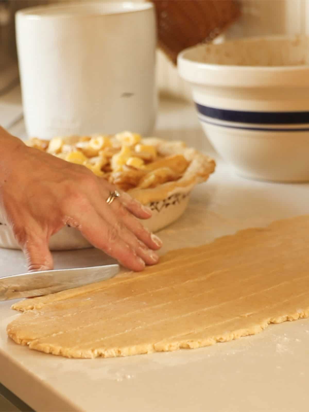 Cutting pie crust into thin strips to make a lattice.