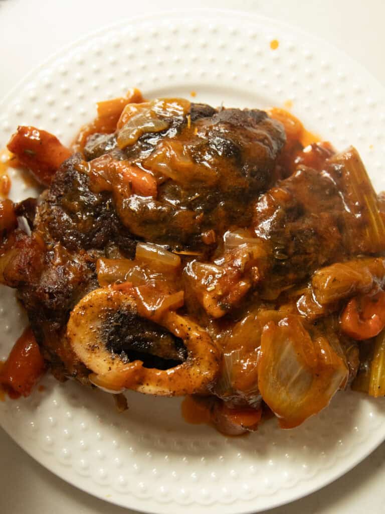 Dutch oven braised beef shank on a white plate.