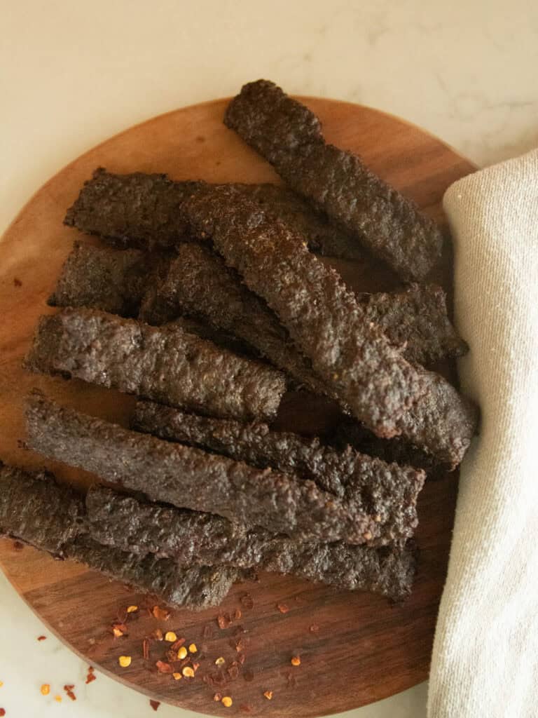 Ground venison jerky on a wooden board.