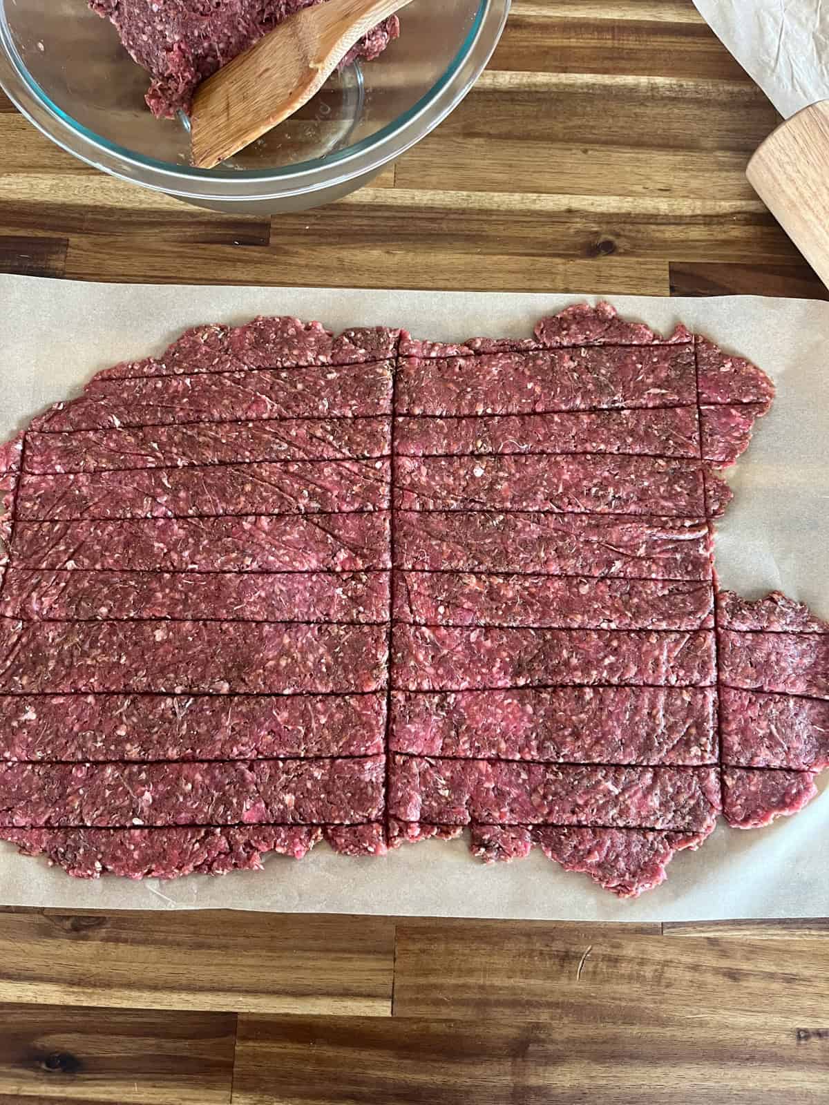 Ground venison meat, rolled flat and sliced into rectangles.