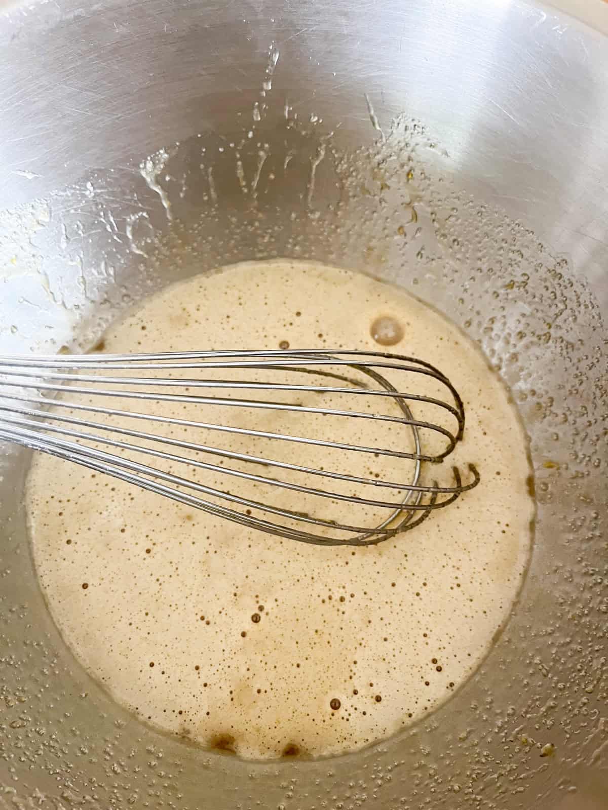 Whisking wet ingredients in a mixing bowl.