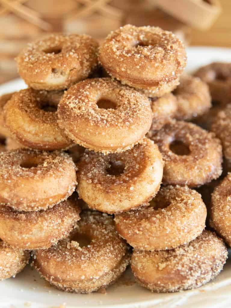 A stack of whole wheat apple cider donuts on a white plate.