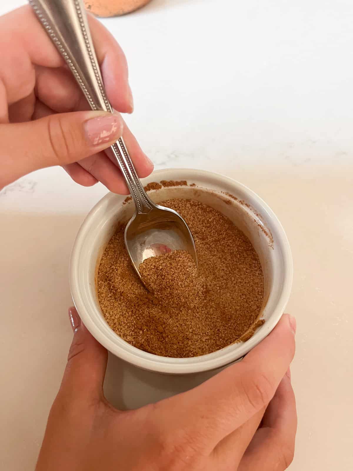 Mixing cinnamon sugar in a small bowl.