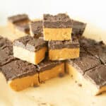 Peanut butter chocolate bars stacked on a wooden board.