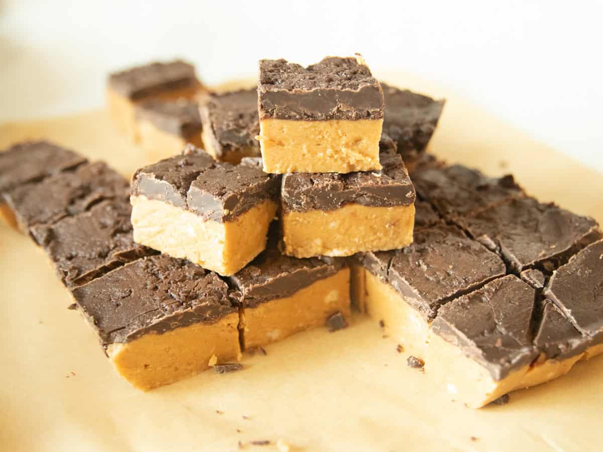 Peanut butter chocolate bars stacked on a wooden board.