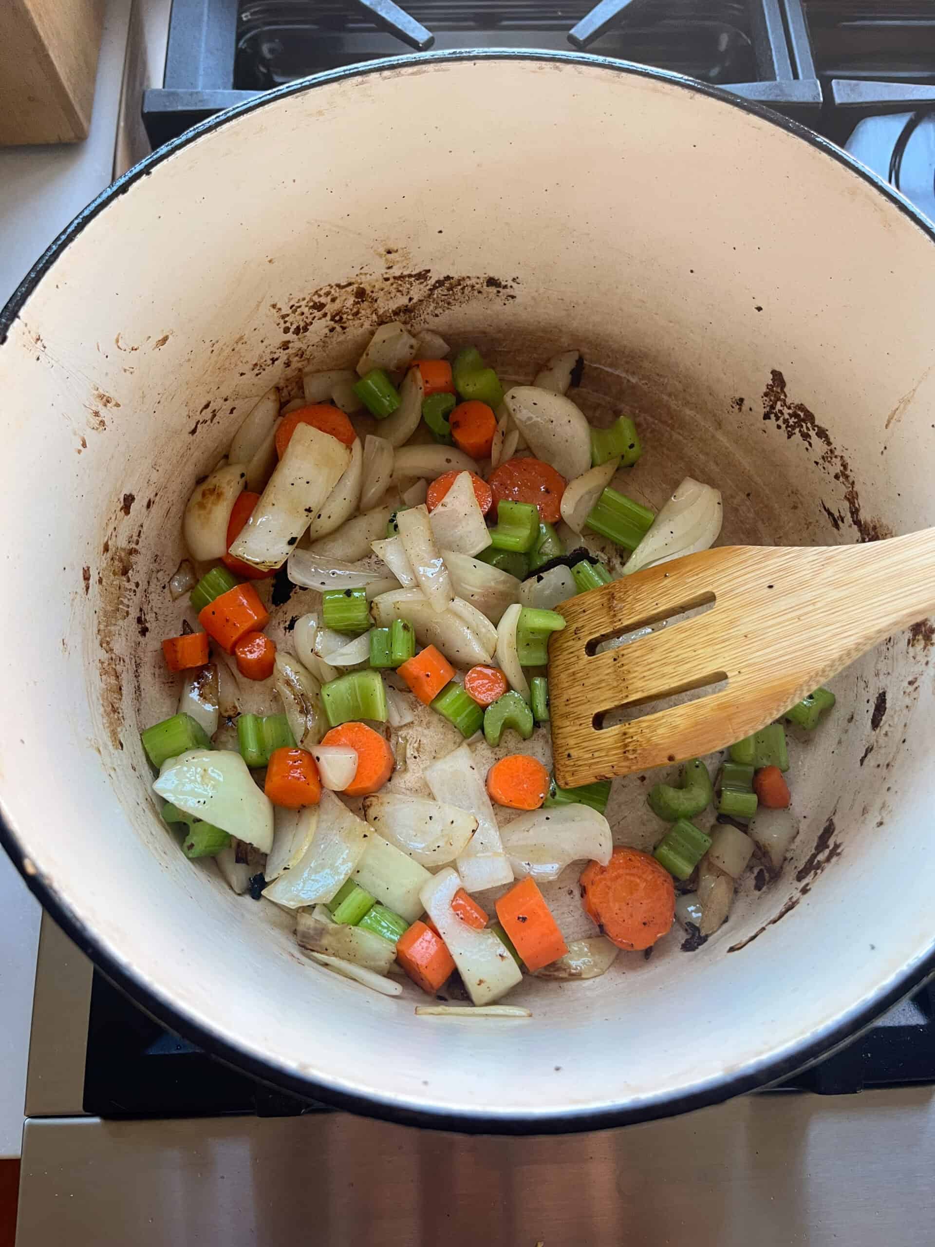 Sauteing carrots, onion, and celery in a dutch oven.