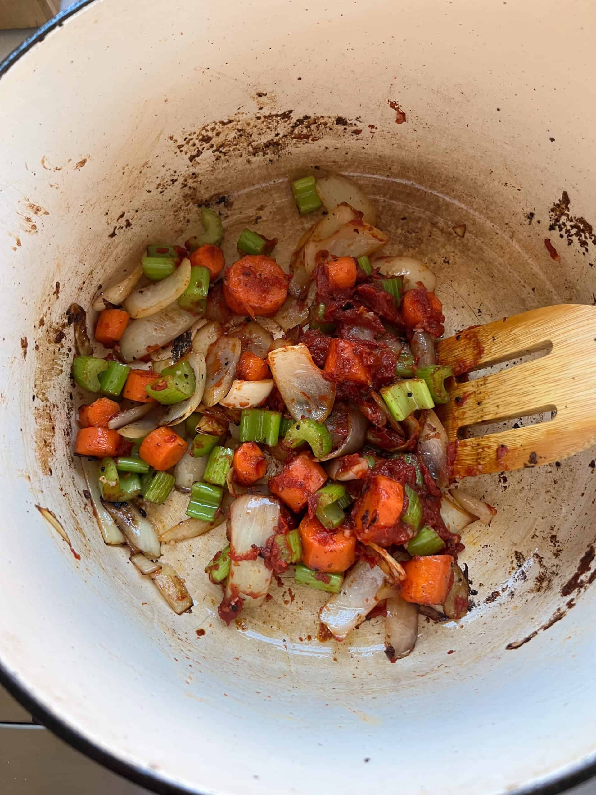 Adding tomato paste and garlic to the veggies.