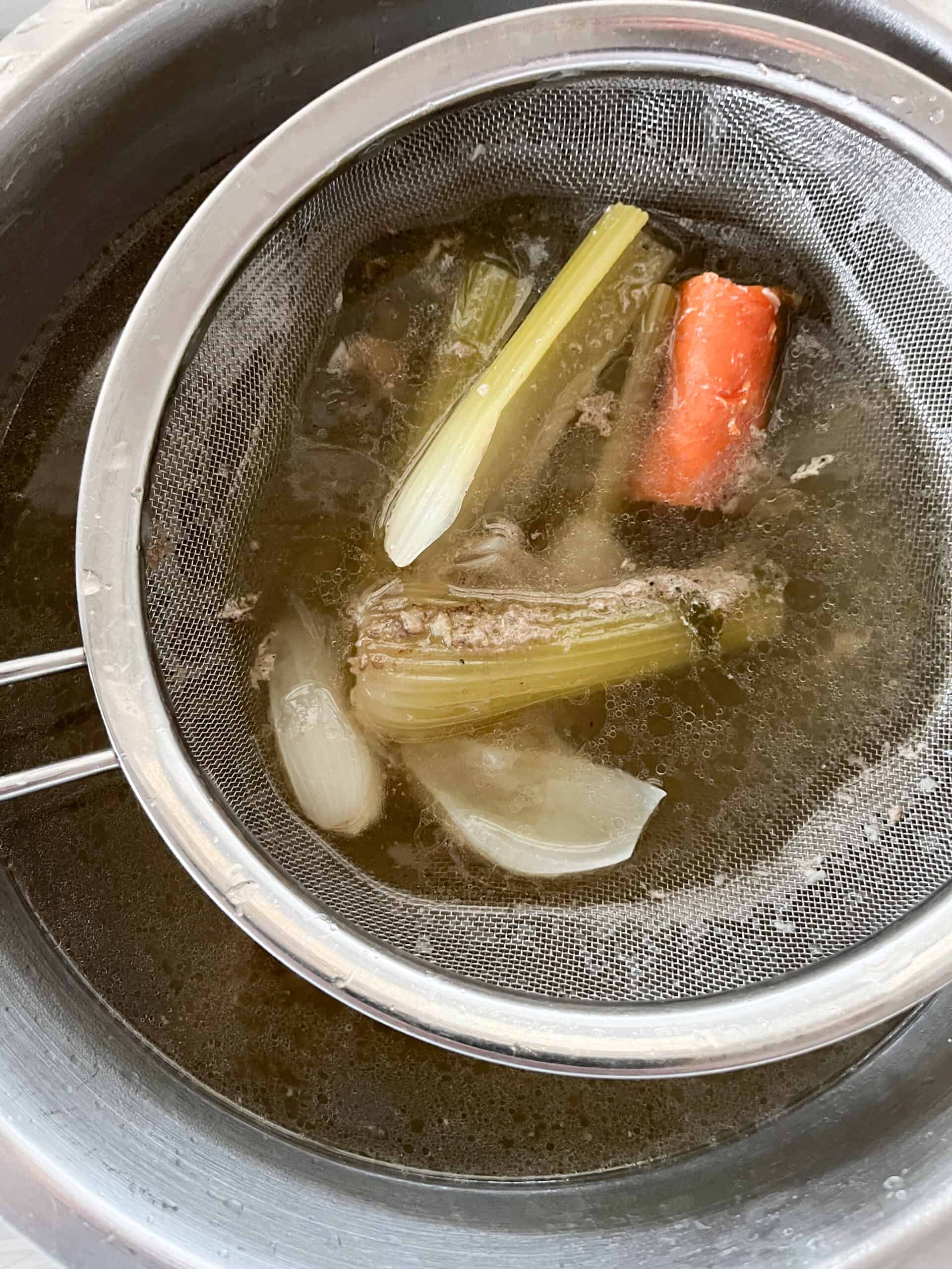 Straining the chicken broth.