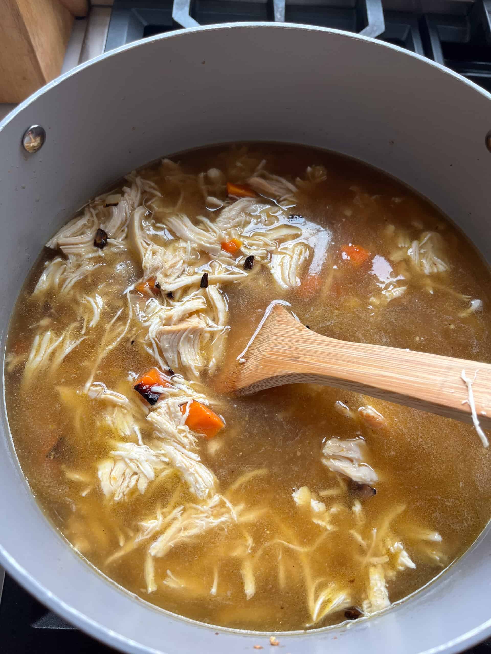 Stirring white chicken chili in a Dutch oven.